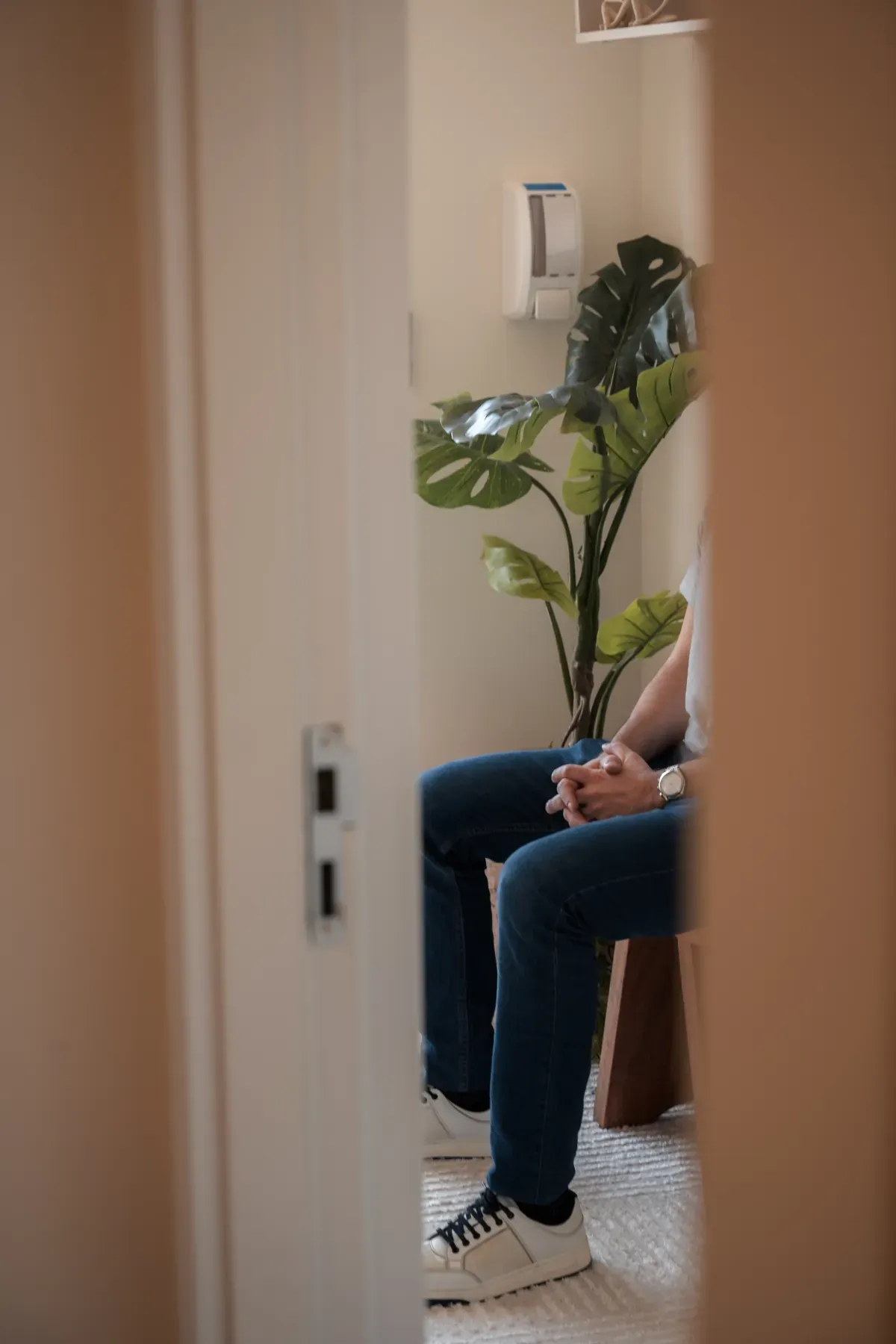 Paciente aguardando na sala de espera, com planta ao lado