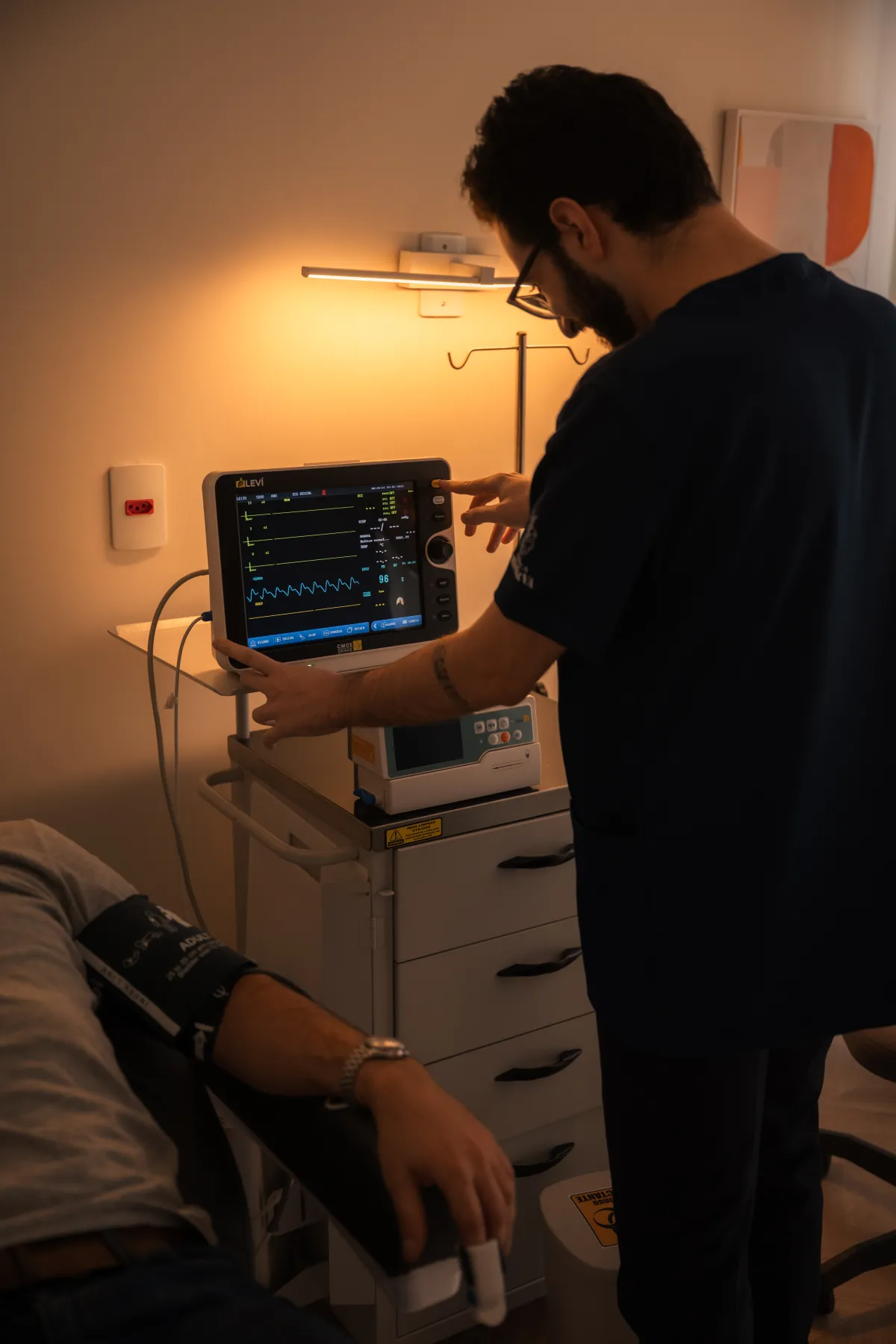 Médico verificando os sinais vitais no monitor durante a sessão